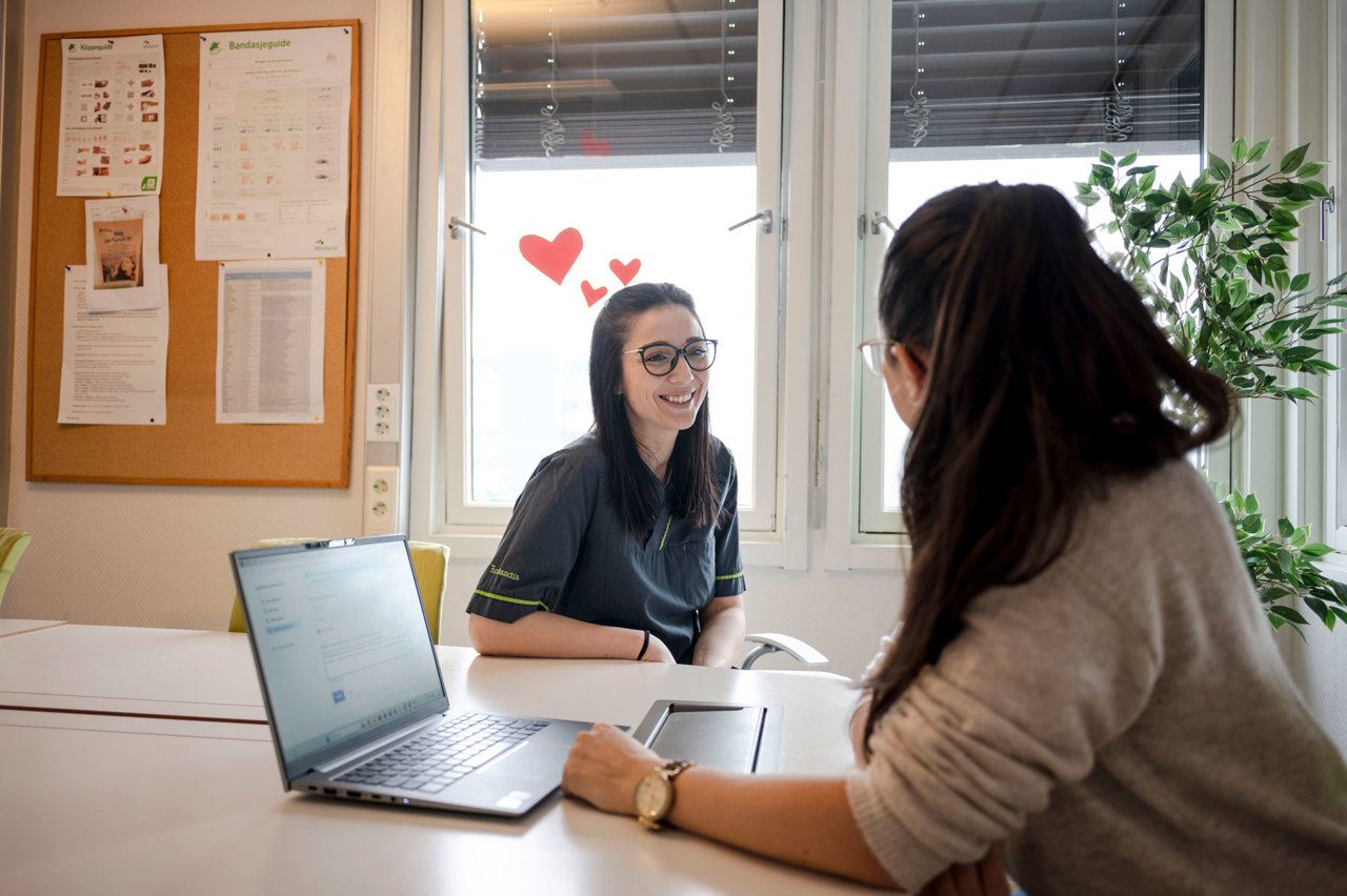 Miruna sitter på kontoret og snakker med en kollega